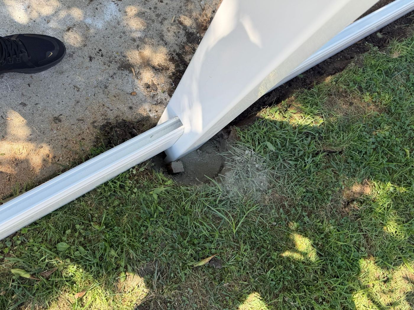 New fence post set in concrete during a fence repair